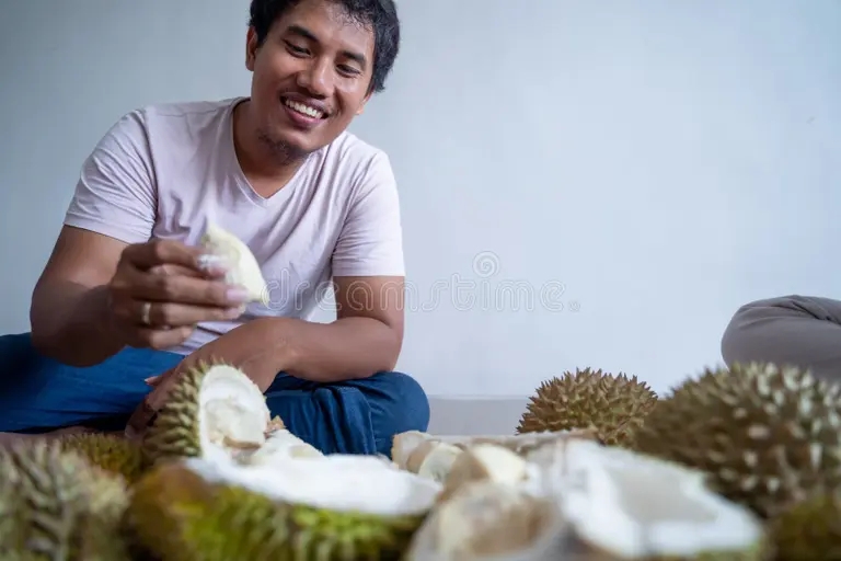 Дуриан asian man enjoy eating durian fruit happy young alone 170114818 - Дуриан