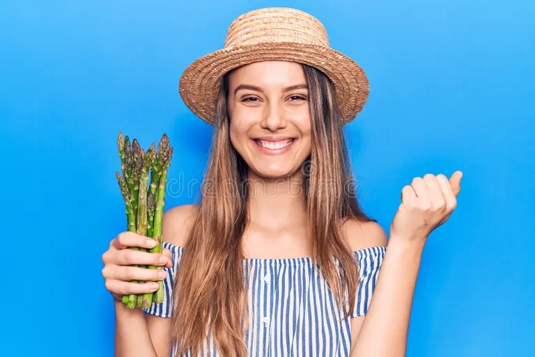 jovencita hermosa con sombrero sosteniendo esparragos gritando orgullosa celebracion de la victoria y el exito muy emocionado 227101334 - Аспарагус